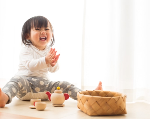 Seorang bayi yang bahagia karena ini adalah kali pertamanya belajar duduk image banner