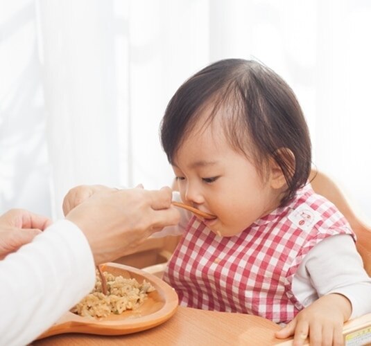 Ibu sedang memberi makan bayinya dengan nasi